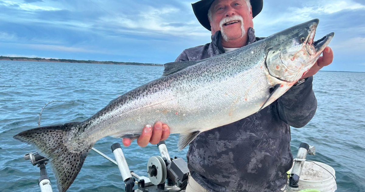 Man holding huge salmon caught charter fishing in Port Washington